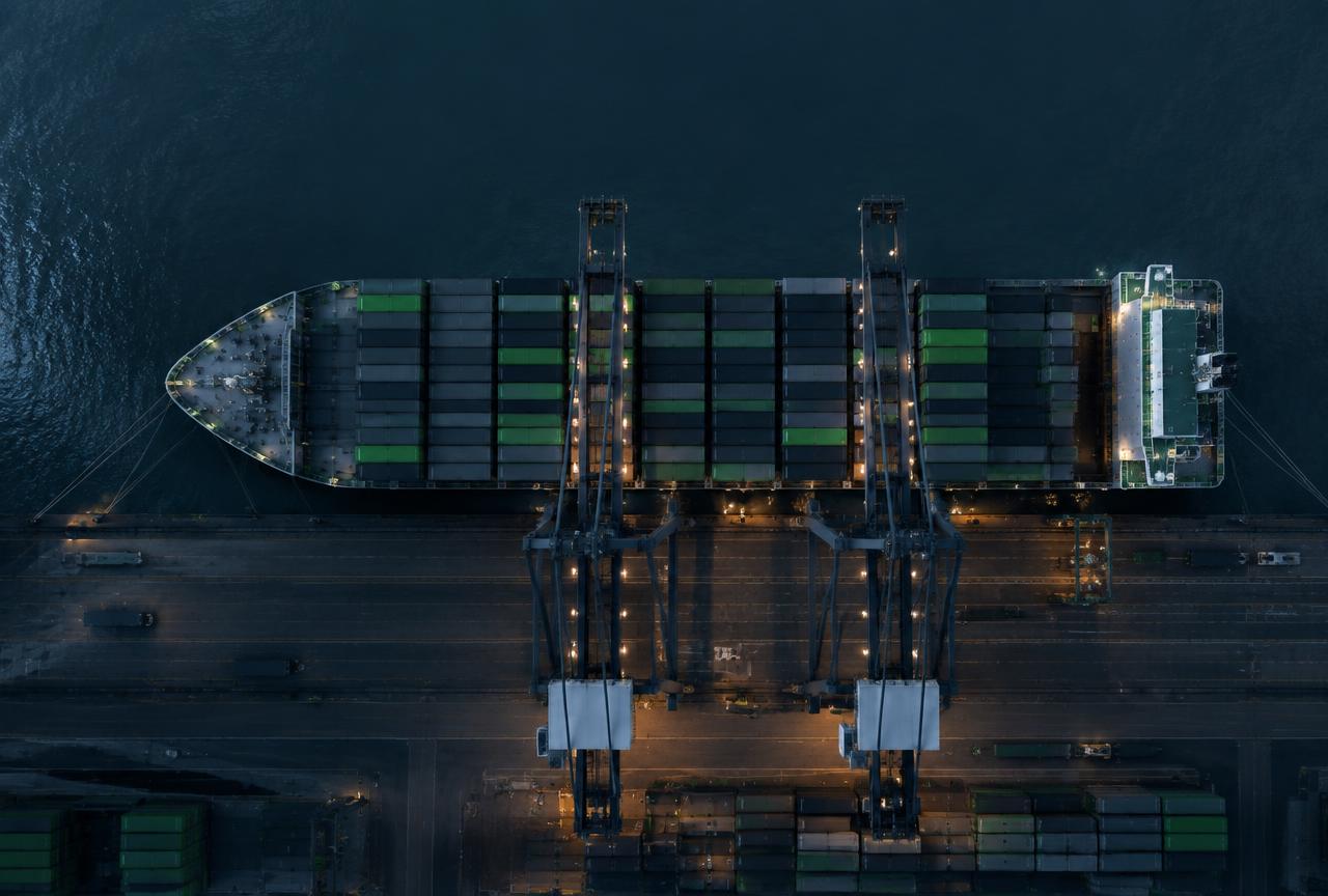 An aerial view of a container ship being loaded at night