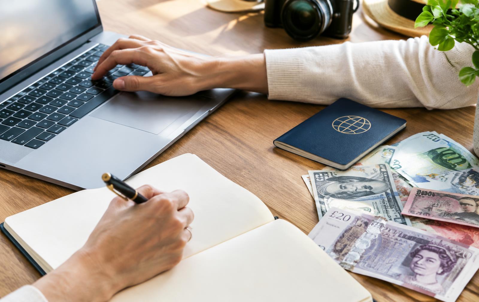 Planning an international transfer with a laptop and banknotes